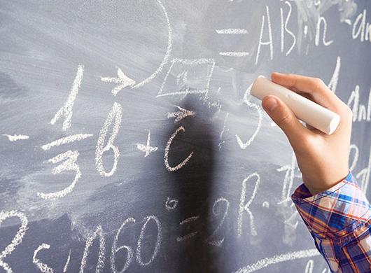 photo of a child resolving a mathematical problem on a blackboard